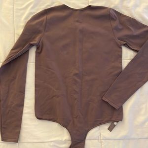 Skims crew neck long sleeve bodysuit in amethyst color.